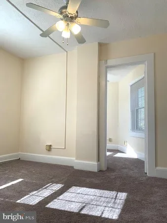 a view of a bedroom with wooden floor and a ceiling fan