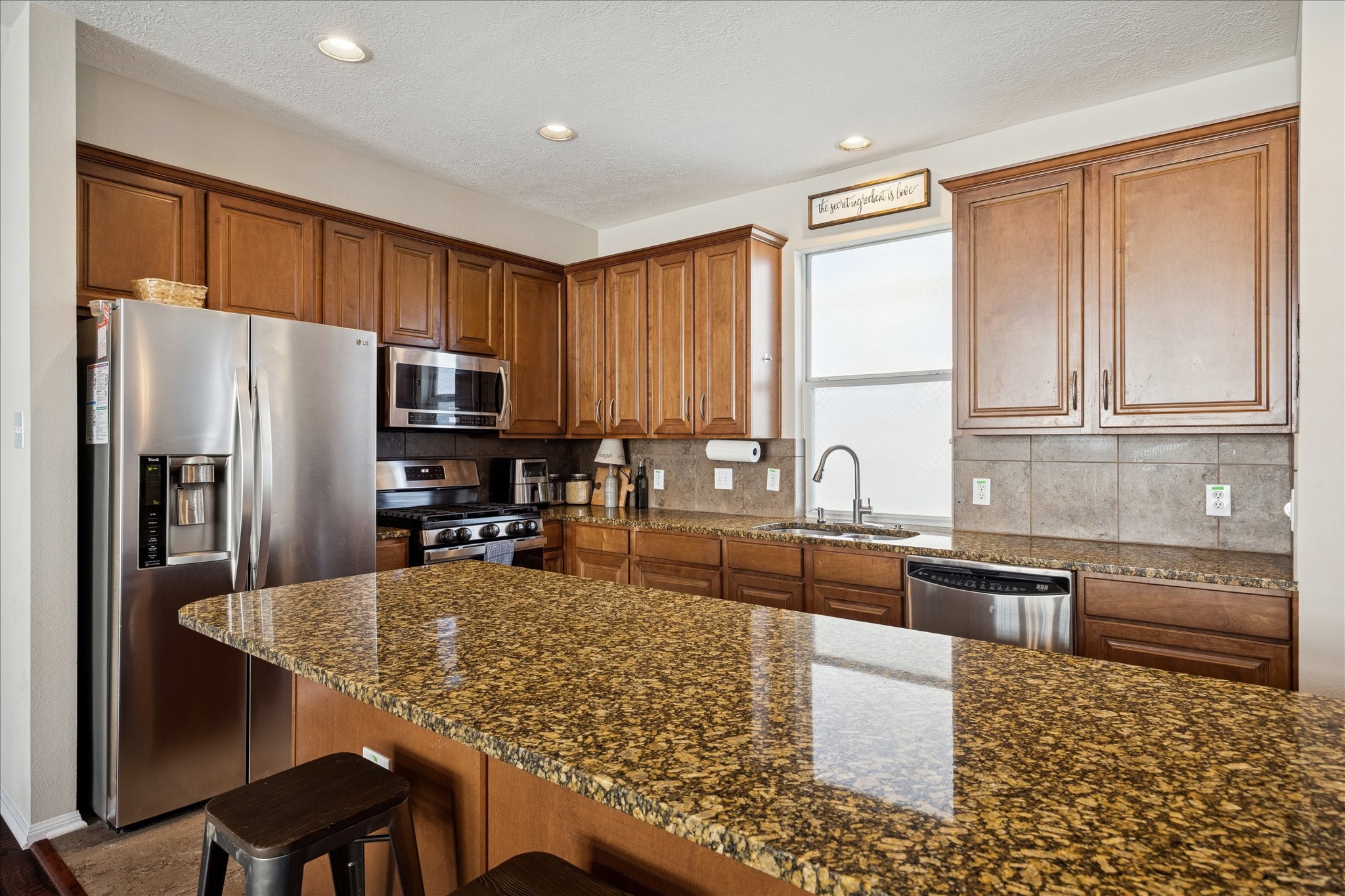 3332 Masters Point Drive Houston, TX 77091 - Photo 3 of 21 a kitchen with granite countertop a refrigerator stove microwave and sink