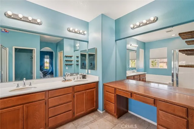 a bathroom with double vanity and a large mirror