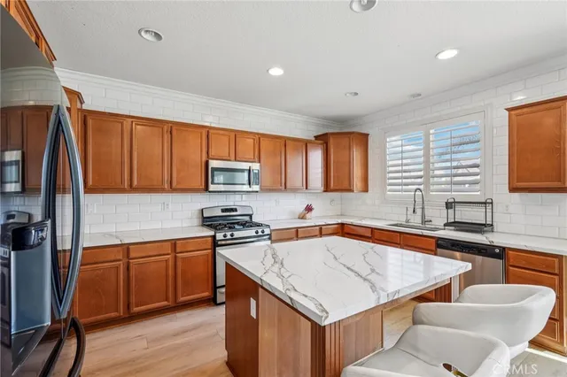 a kitchen with stainless steel appliances granite countertop a sink stove microwave and refrigerator