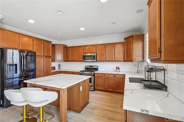 a kitchen with stainless steel appliances granite countertop table chairs sink and wooden floor