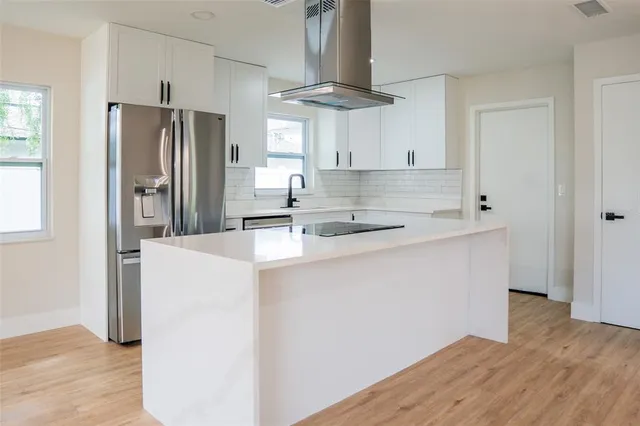 a kitchen with stainless steel appliances a sink and a refrigerator