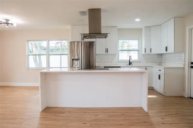 a kitchen with stainless steel appliances granite countertop a sink a stove and a refrigerator