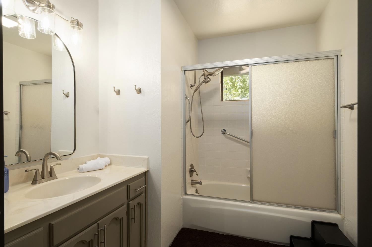 42488 Rock Ledge Road Shaver Lake, CA 93664 - Photo 23 of 26 a bathroom with a shower sink and mirror