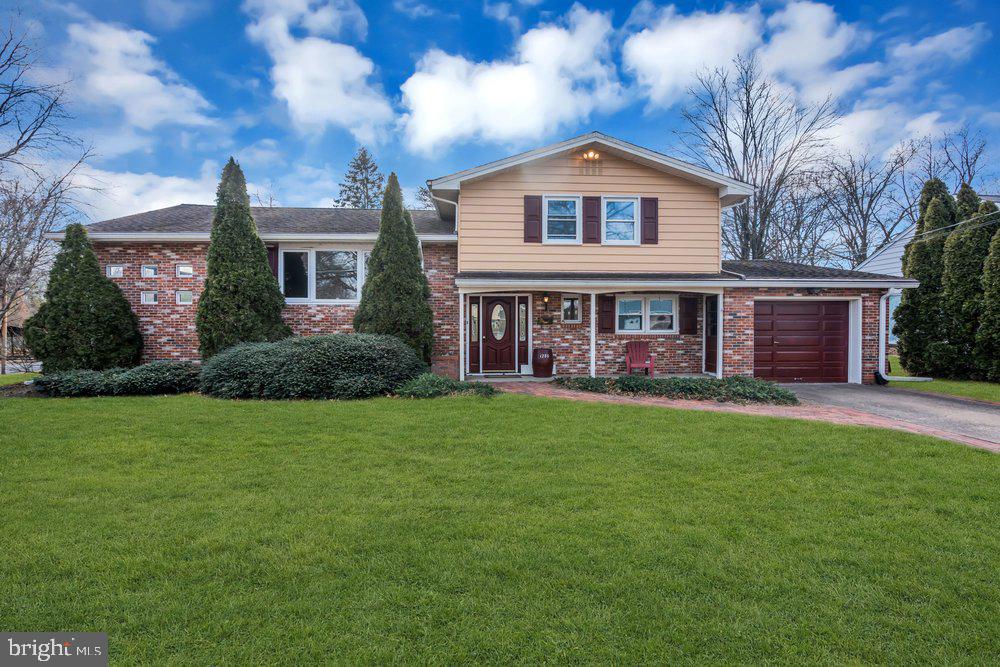 a front view of a house with yard and green space