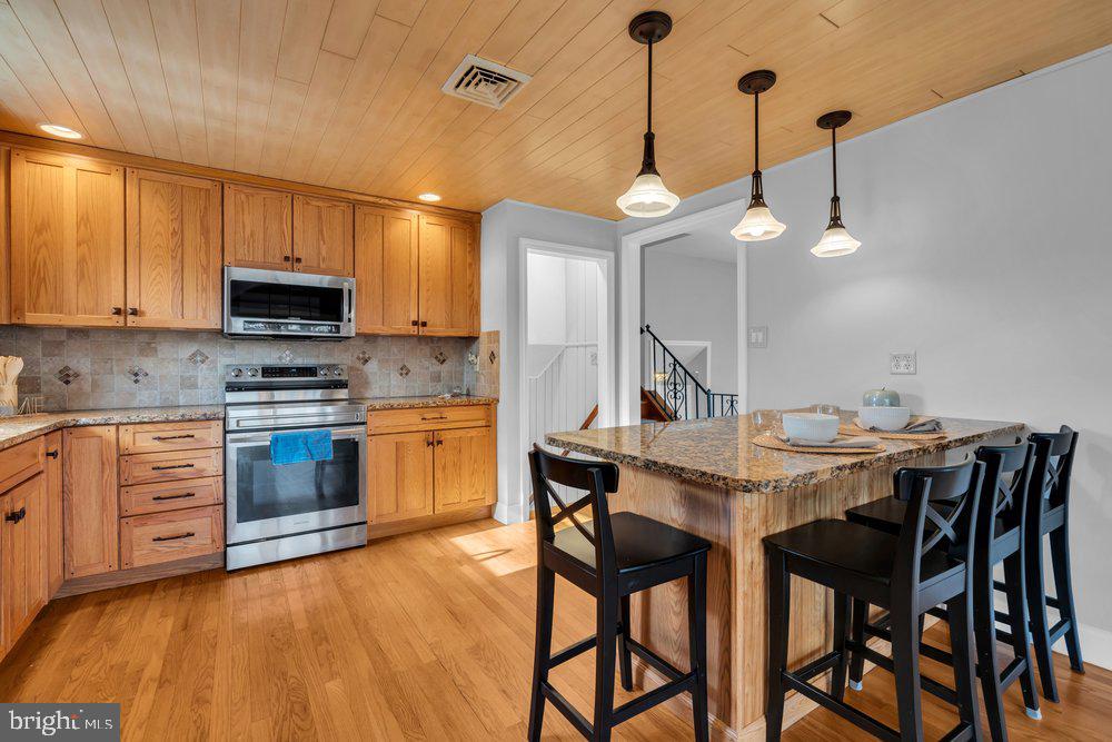 1280 School Lane Roebling, NJ 08554 - Photo 16 of 34 a kitchen with a stove a microwave a dining table and chairs