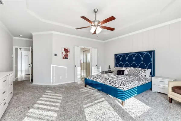 a bedroom with a large bed and a chandelier