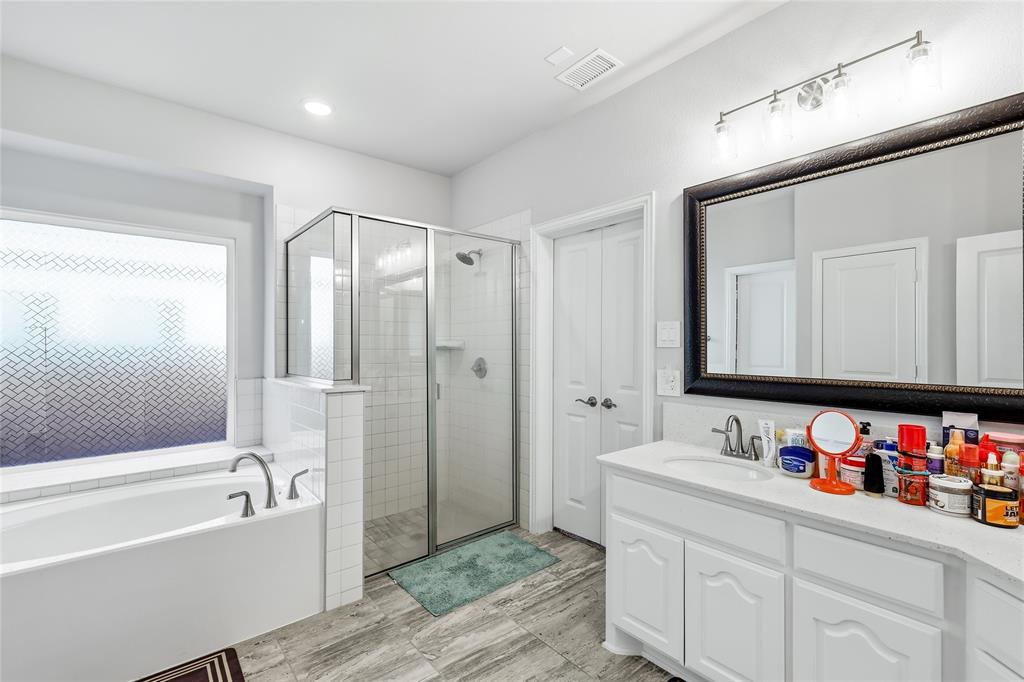 1315 Cascade Lane Forney, TX 75126 - Photo 28 of 36 a bathroom with a tub sink double vanity and a mirror