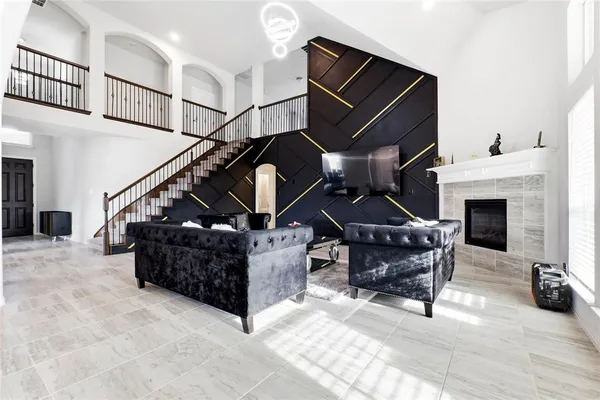 a living room with furniture a fireplace and a ceiling fan