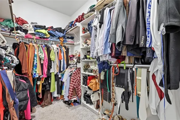 a view of walk in closet with clothes