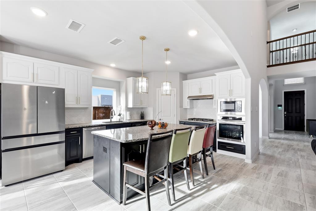 1315 Cascade Lane Forney, TX 75126 - Photo 8 of 36 a kitchen with kitchen island a dining table wooden floor cabinets and appliances