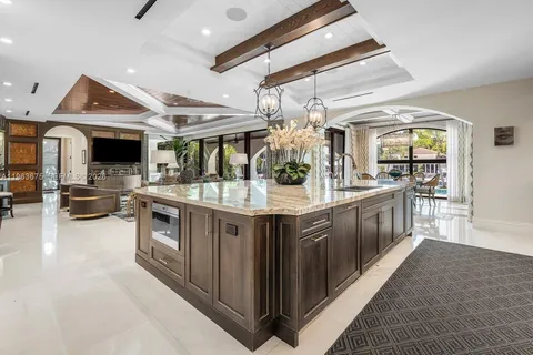 a living room with couches a dining table and chairs with a floor to ceiling window