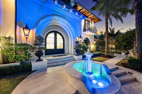 a front view of a house with garden and fountain