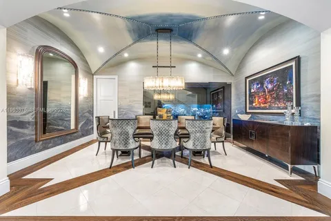 a living room with furniture a chandelier and a floor to ceiling window