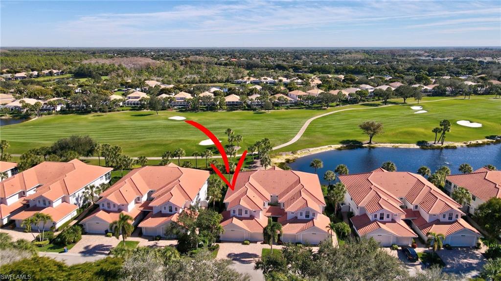 Aerial view of residential area with a nearby body of water and a local golf course