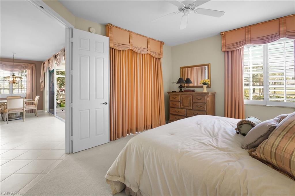23081 Rosedale Drive, Unit 101 Estero, FL 34135 - Photo 16 of 38 a bedroom with a large bed and a chandelier