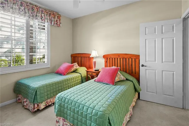 a bedroom with two beds and a chandelier