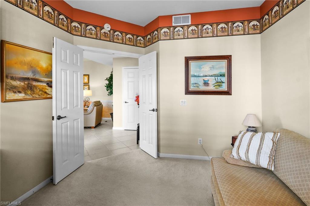 23081 Rosedale Drive, Unit 101 Estero, FL 34135 - Photo 18 of 41 Hallway with light colored carpet and light tile patterned flooring