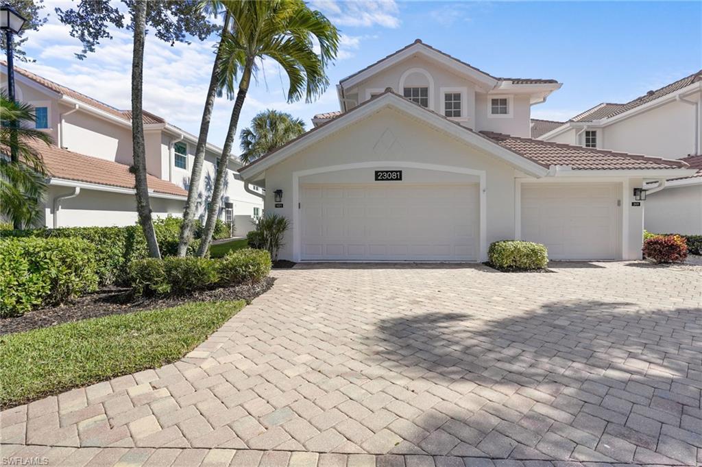 23081 Rosedale Drive, Unit 101 Estero, FL 34135 - Photo 2 of 38 a view of a white house with a yard and potted plants