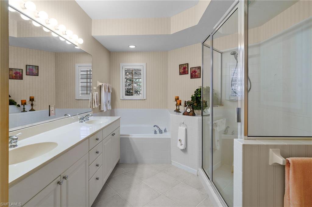 23081 Rosedale Drive, Unit 101 Estero, FL 34135 - Photo 21 of 38 Bathroom featuring wallpapered walls, double vanity, a bath, a stall shower, and recessed lighting