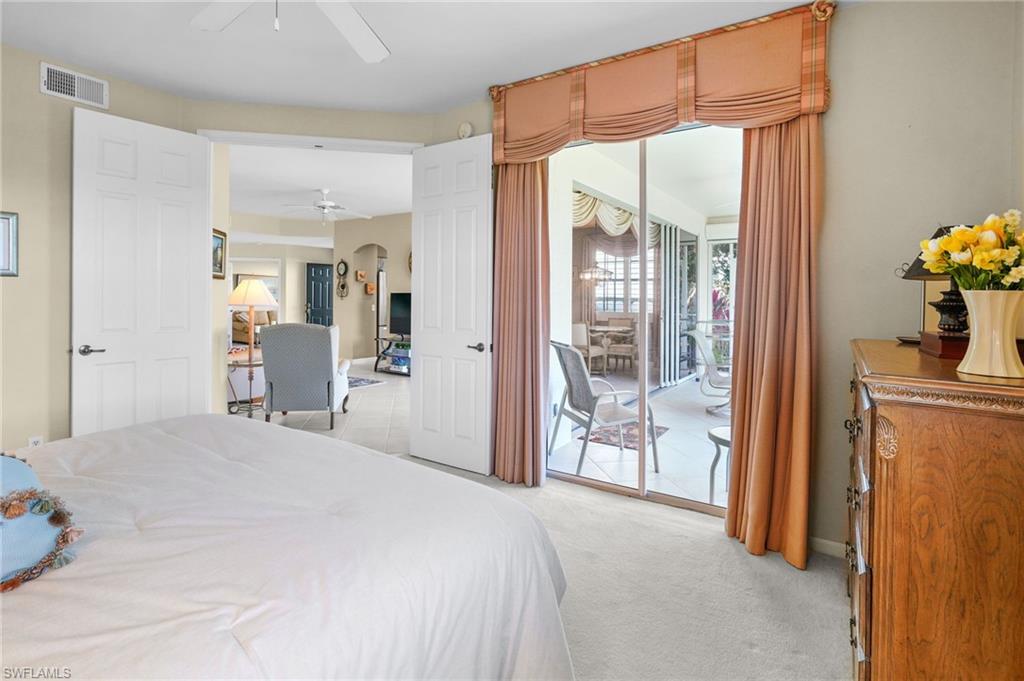 23081 Rosedale Drive, Unit 101 Estero, FL 34135 - Photo 26 of 41 Bedroom with access to exterior, light carpet, arched walkways, and a ceiling fan