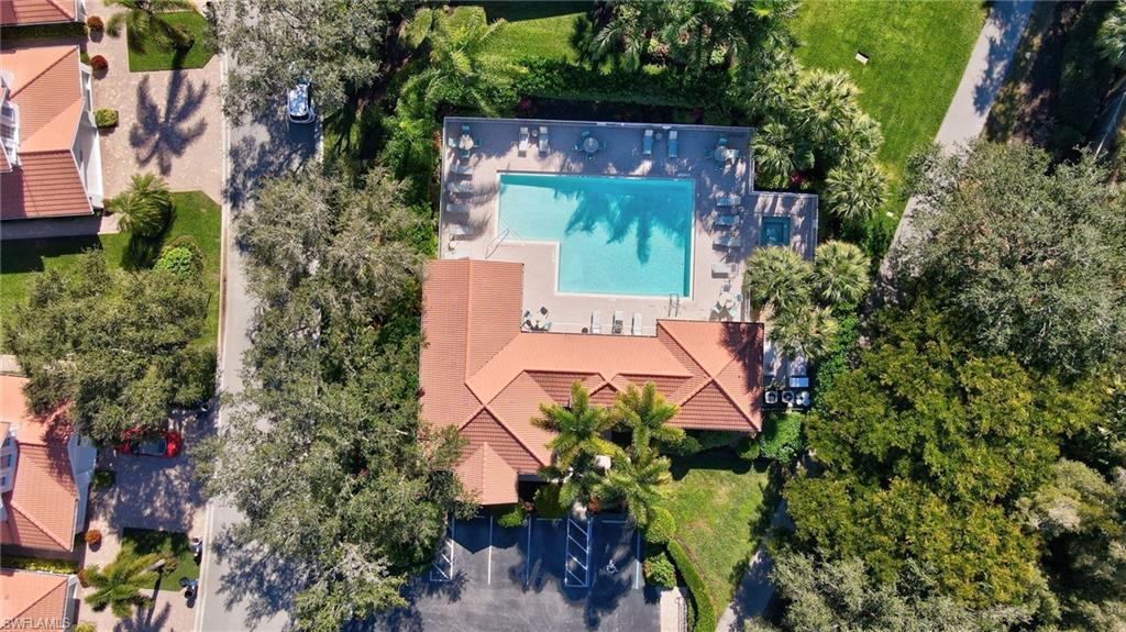 23081 Rosedale Drive, Unit 101 Estero, FL 34135 - Photo 35 of 38 Drone / aerial view of a pool area and a tree filled landscape