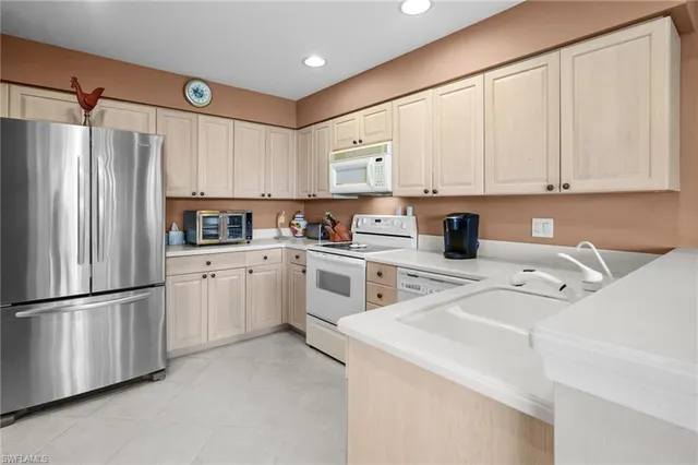 a kitchen with white cabinets and white appliances