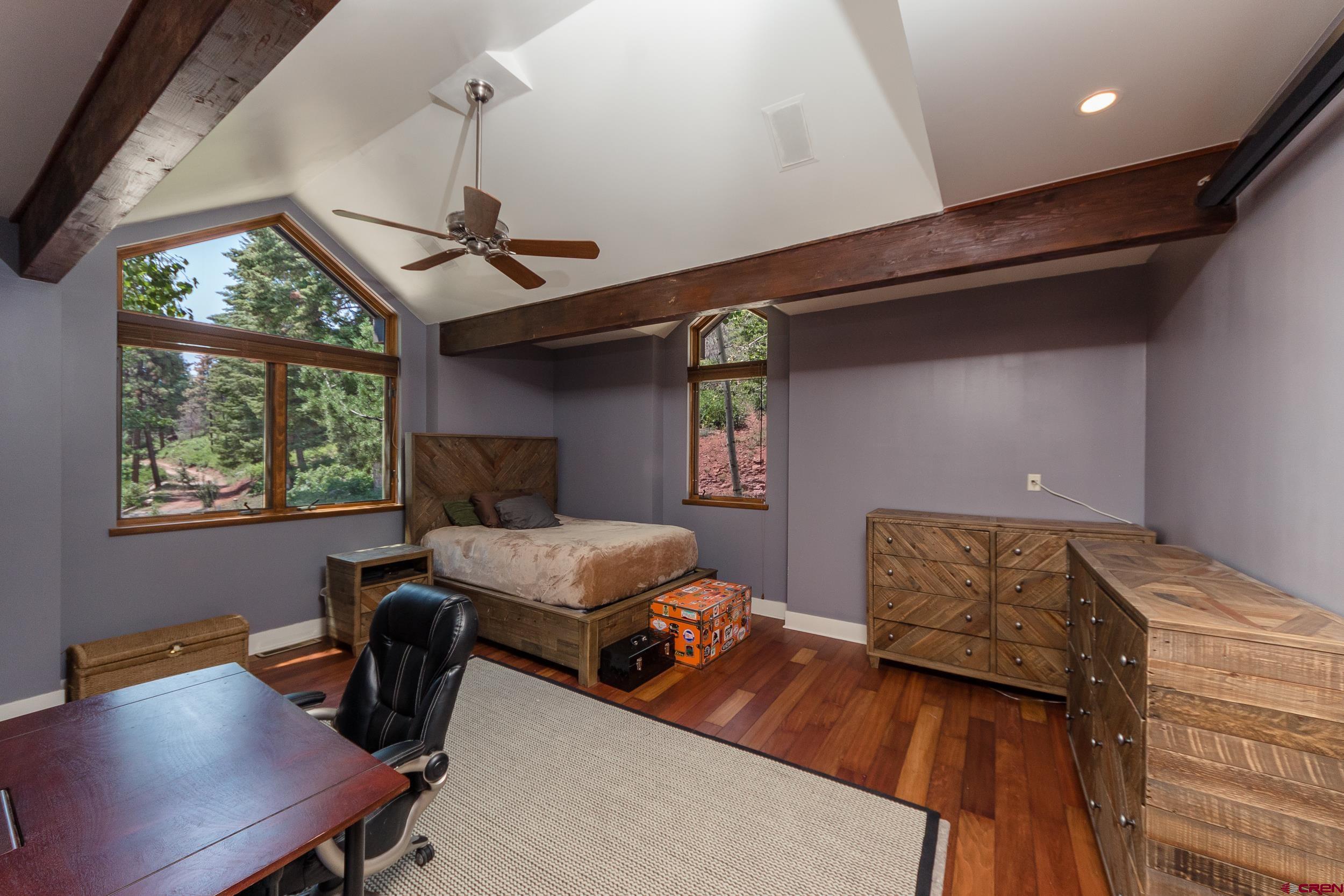 9475 High Meadows Durango, CO 81301 - Photo 20 of 35 a bedroom with a bed a desk and chair with the wooden floor