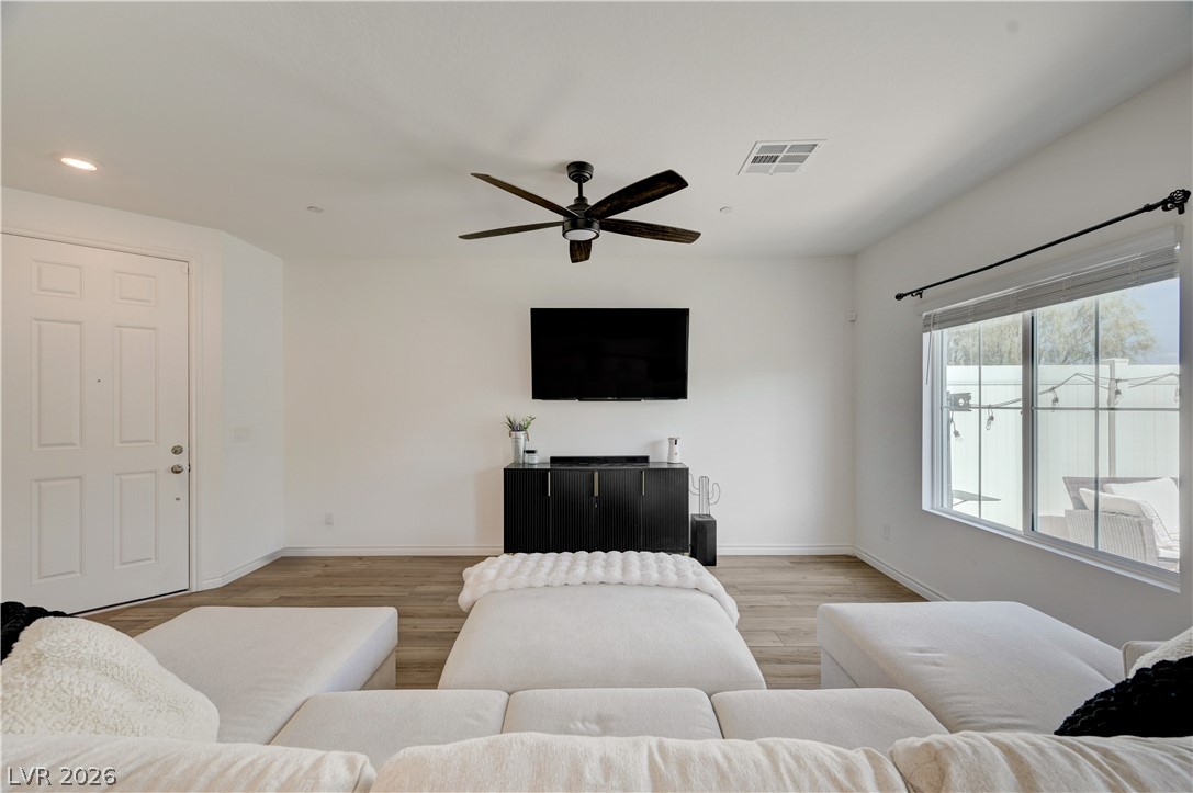 7204 North Decatur Boulevard, Unit 3 North Las Vegas, NV 89084 - Photo 8 of 48 A warm, neutral-toned living area features durable flooring and a stylish ceiling fan.