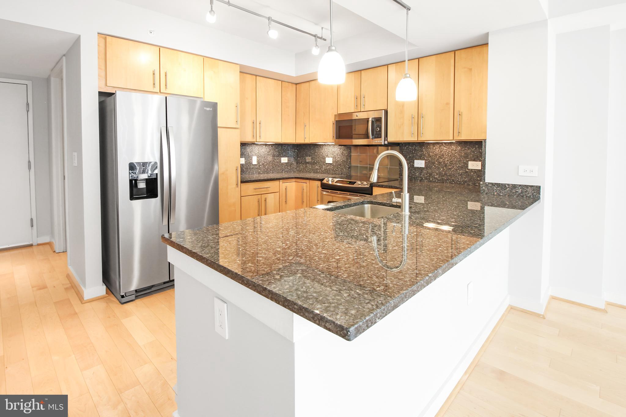 1025 First Street Southeast, Unit 612 Washington, DC 20003 - Photo 4 of 41 a kitchen with stainless steel appliances granite countertop a sink a counter and a refrigerator