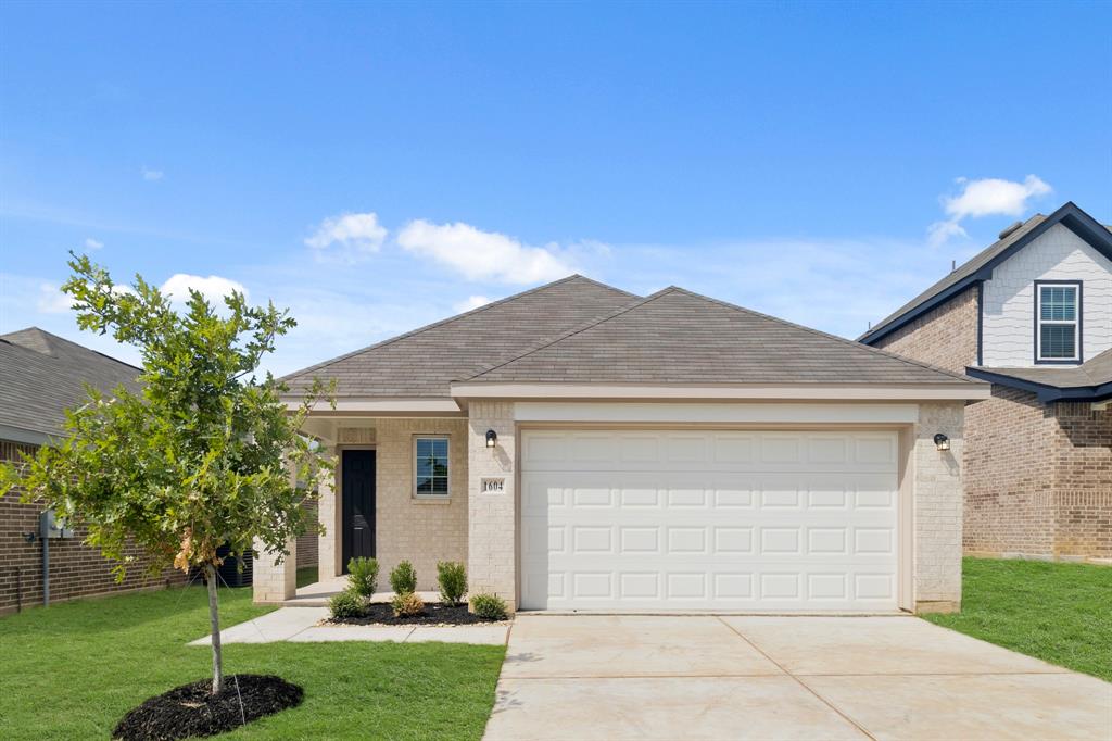 1604 Romans Road Ennis, TX 75119 - Photo 1 of 15 a front view of a house with a yard and garage