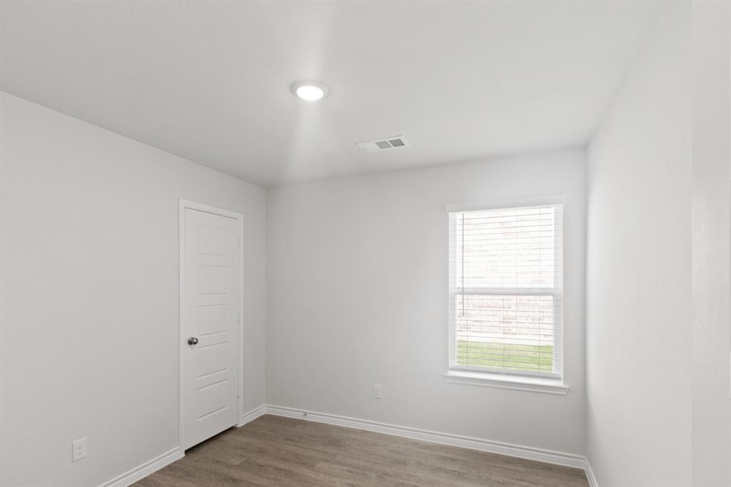 1604 Romans Road Ennis, TX 75119 - Photo 11 of 15 an empty room with wooden floor and windows
