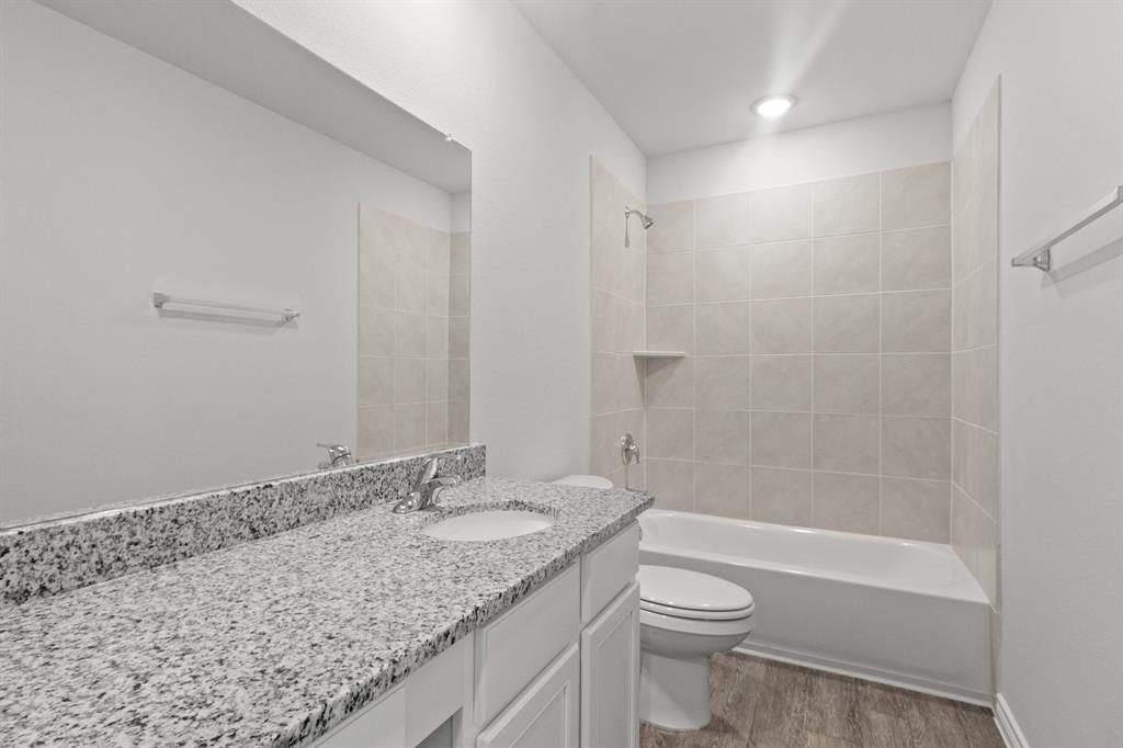 1604 Romans Road Ennis, TX 75119 - Photo 12 of 15 a bathroom with a granite countertop sink a toilet and shower