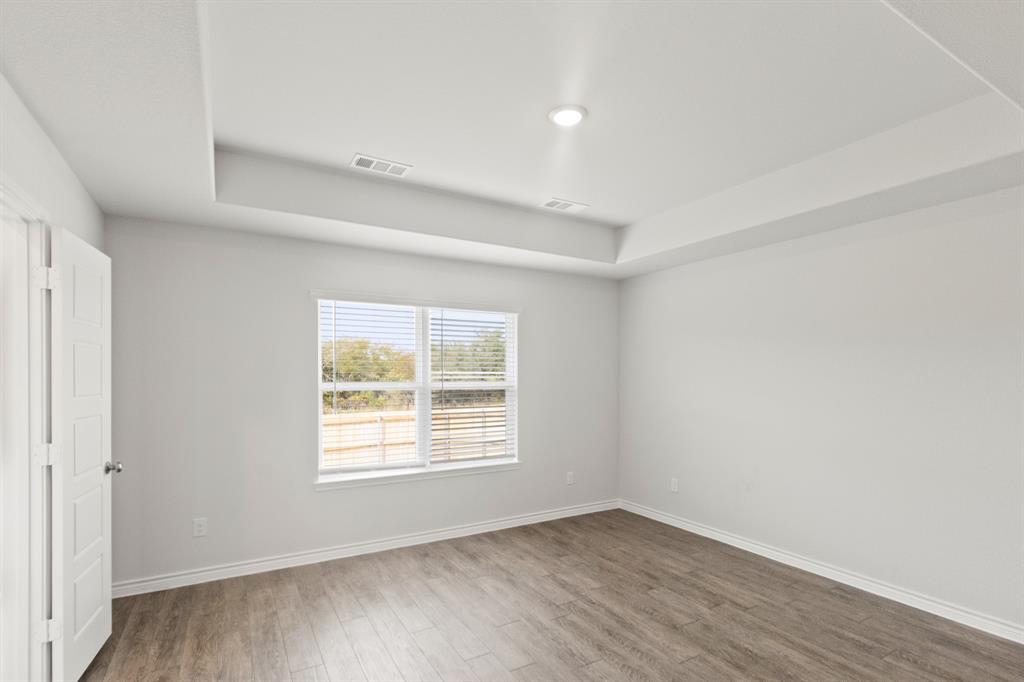 1604 Romans Road Ennis, TX 75119 - Photo 13 of 15 an empty room with wooden floor and windows