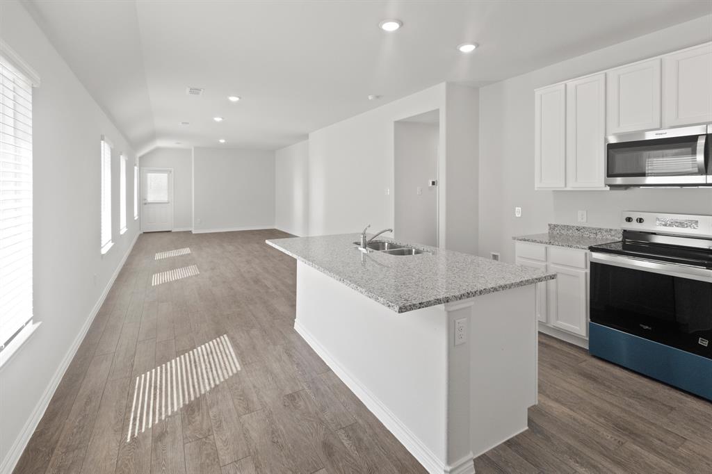 1604 Romans Road Ennis, TX 75119 - Photo 4 of 15 a kitchen with stainless steel appliances granite countertop a sink stove and cabinets