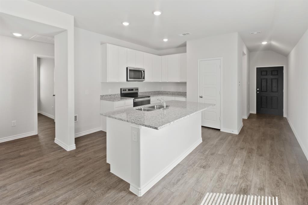 1604 Romans Road Ennis, TX 75119 - Photo 5 of 15 a kitchen with kitchen island sink stove and refrigerator