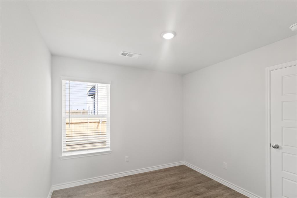 1604 Romans Road Ennis, TX 75119 - Photo 9 of 16 an empty room with wooden floor and windows