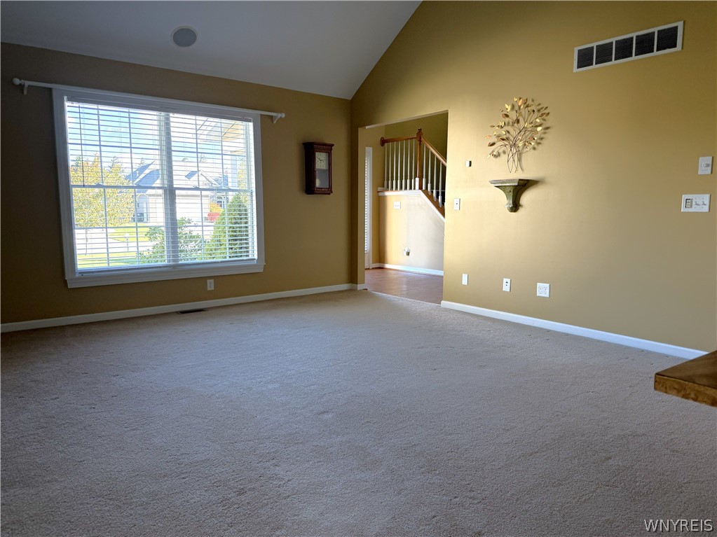 73 Chestnut Lancaster, NY 14086 - Photo 7 of 41 Vaulted ceilings and a large window define this spacious living area with wall-to-wall carpeting.