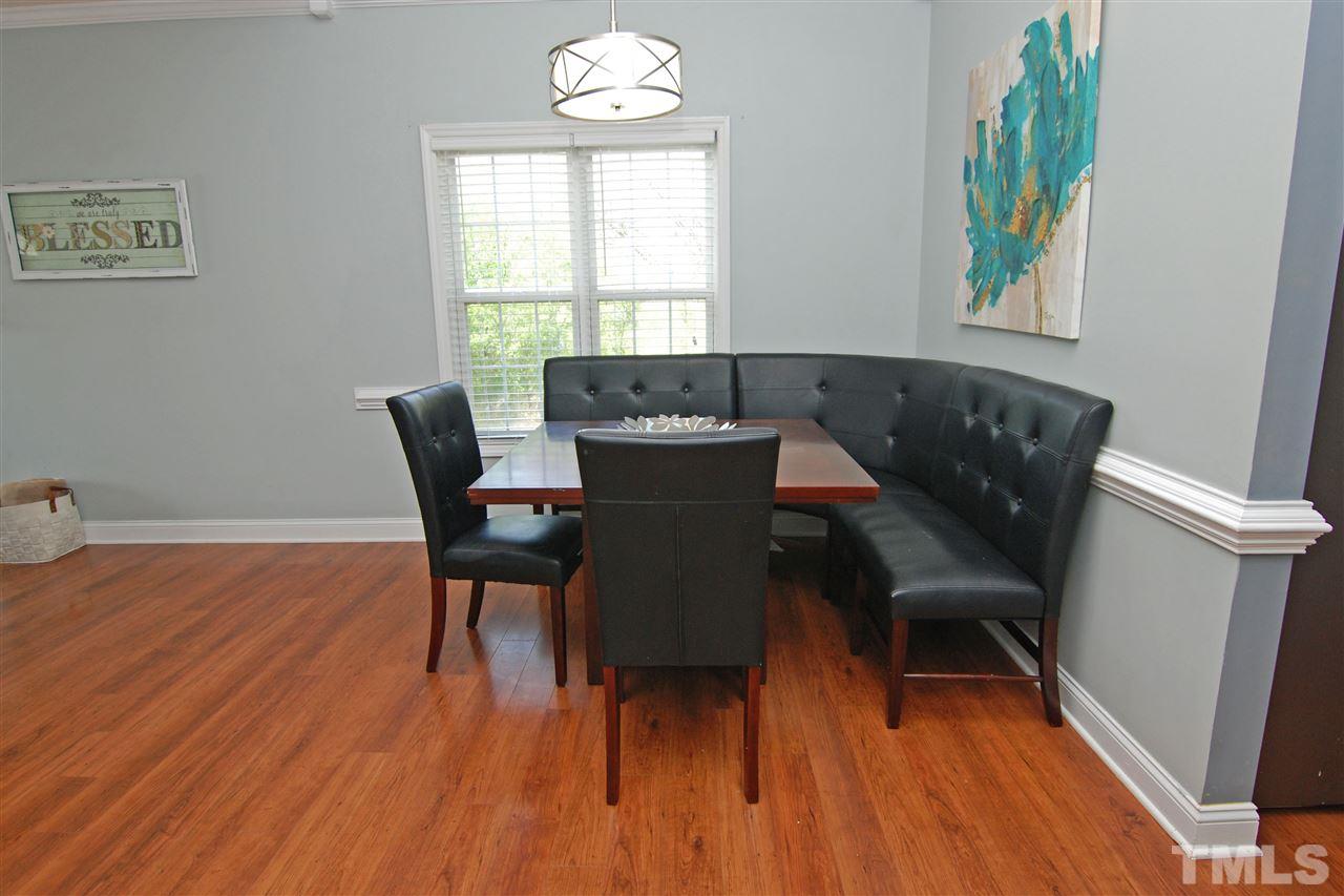 4501 Pinckney Place Raleigh, NC 27604 - Photo 11 of 22 a view of a dining room with furniture a chandelier and wooden floor