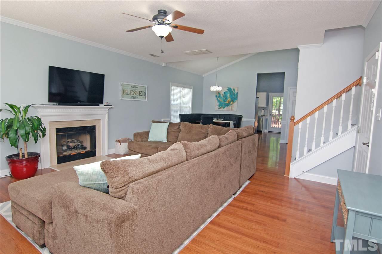 4501 Pinckney Place Raleigh, NC 27604 - Photo 7 of 22 a living room with furniture a flat screen tv and a fireplace