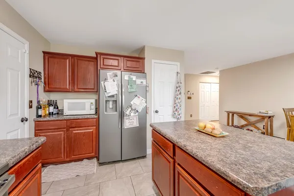 a kitchen with granite countertop a sink cabinets and stainless steel appliances