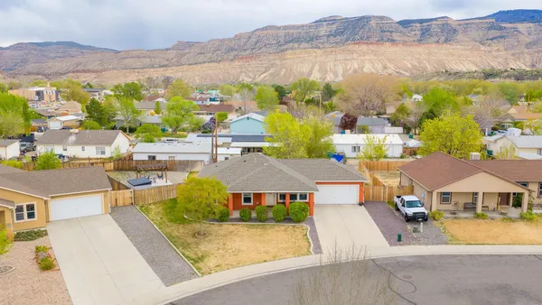 an aerial view of residential houses with outdoor space and parking