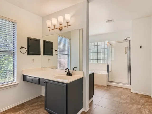 a bathroom with a tub sink and mirror
