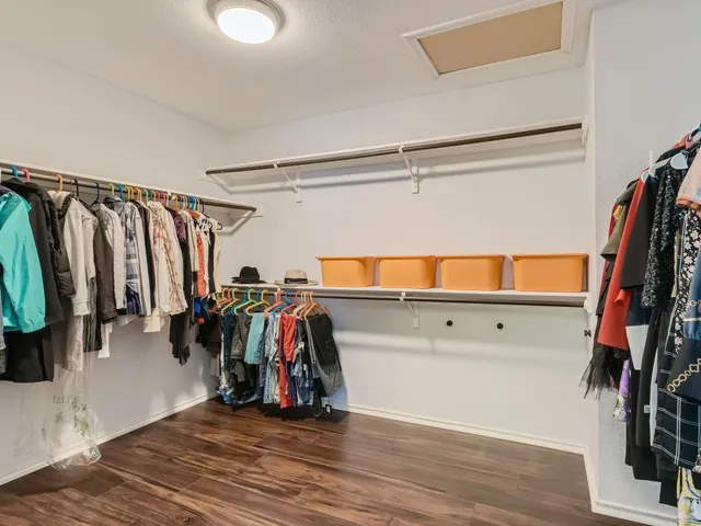 a view of walk in closet with clothes and shoes