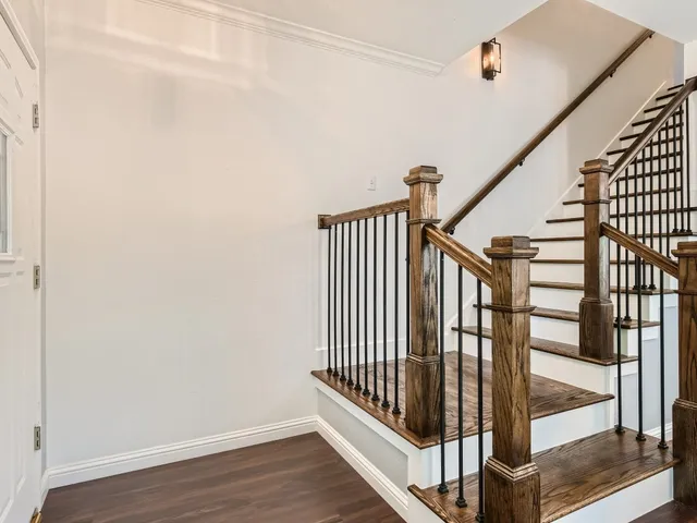 a view of staircase with railing and white walls