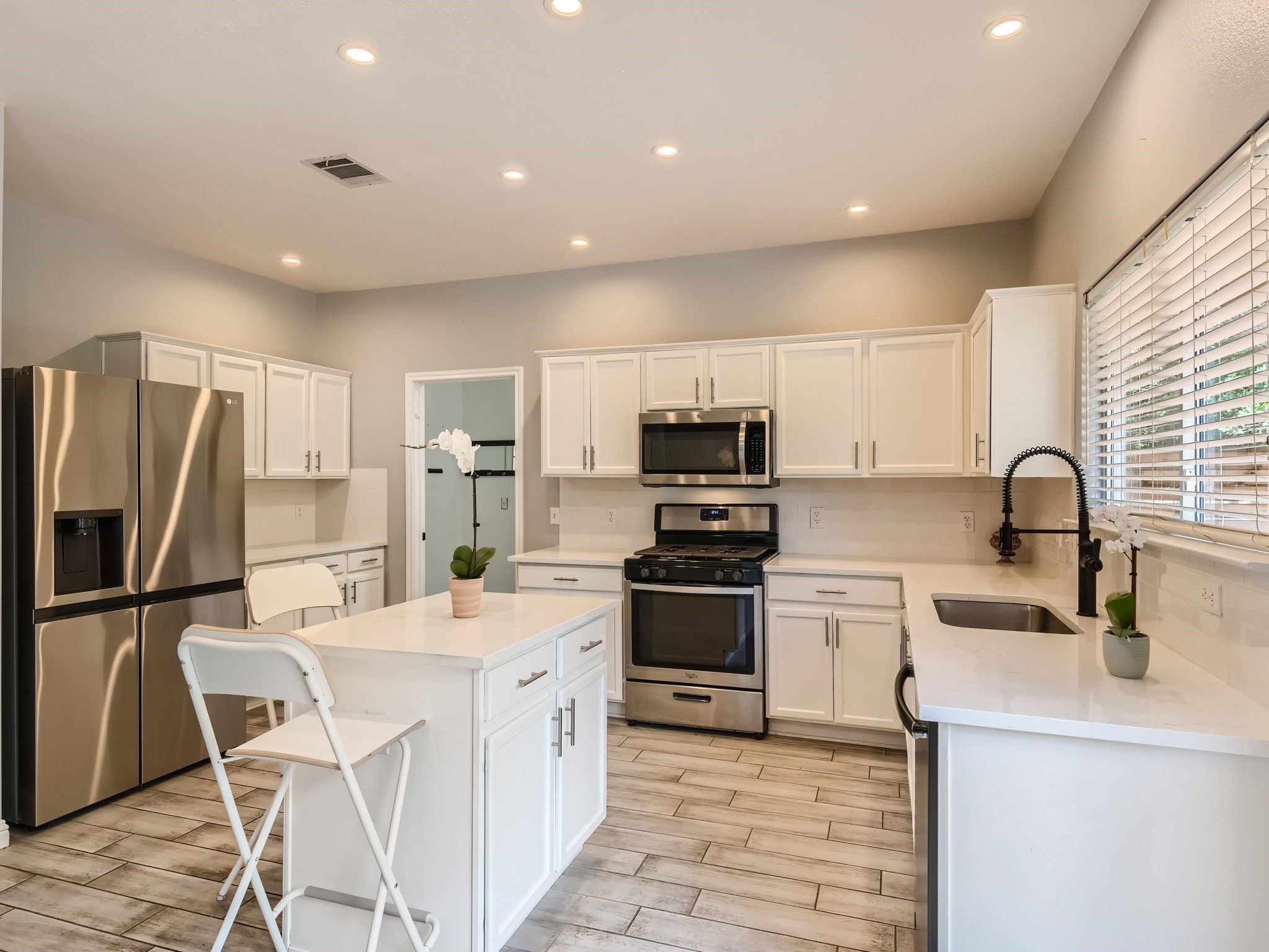 5904 Kabaye Cove Austin, TX 78749 - Photo 9 of 28 a kitchen with stainless steel appliances a stove top oven a refrigerator a sink dishwasher with a dining table and chairs
