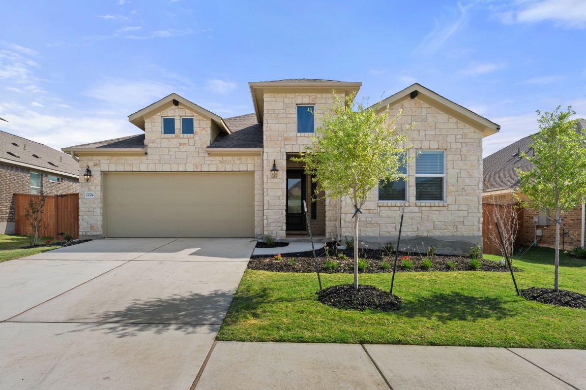 2004 Long Shadow Lane Georgetown, TX 78628 - Photo 1 of 1 a front view of a house with a yard and garage