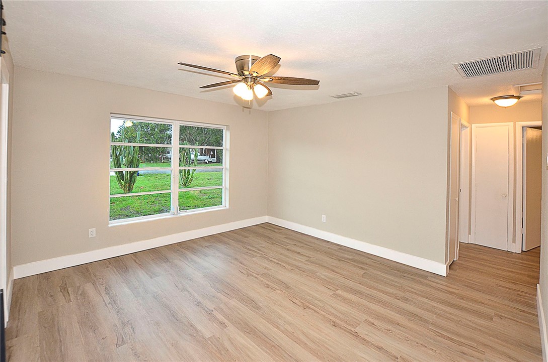355 6th Road Southwest Vero Beach, FL 32962 - Photo 13 of 23 an empty room with wooden floor fan and windows