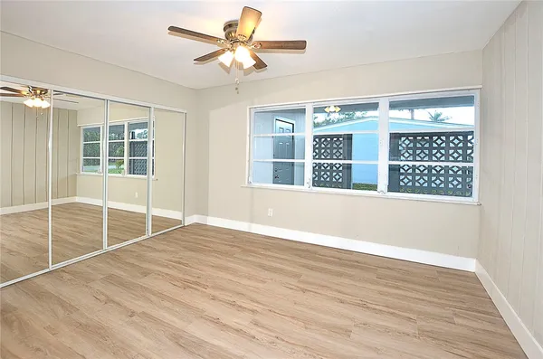 a view of an empty room with a window and wooden floor