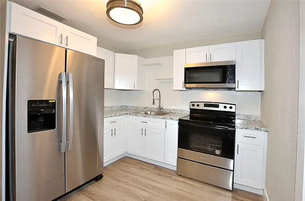 a kitchen with a refrigerator stove and microwave